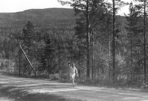 Soihdunkantaja juoksee autiolla tiellä Lapissa 7.7.1952. -0